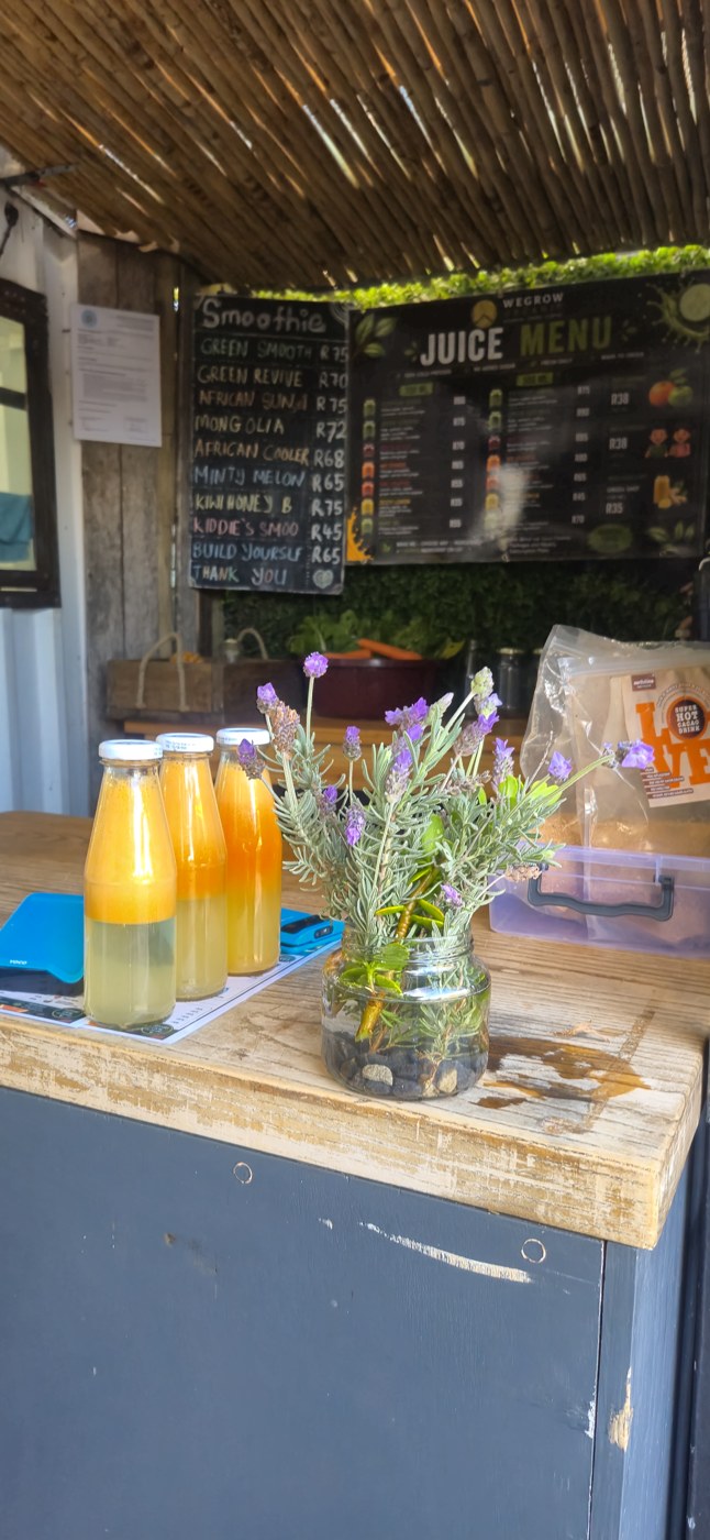 Fresh cold-pressed juice bottles on the WeGrowOrganic juice bar counter beneath the juice menu